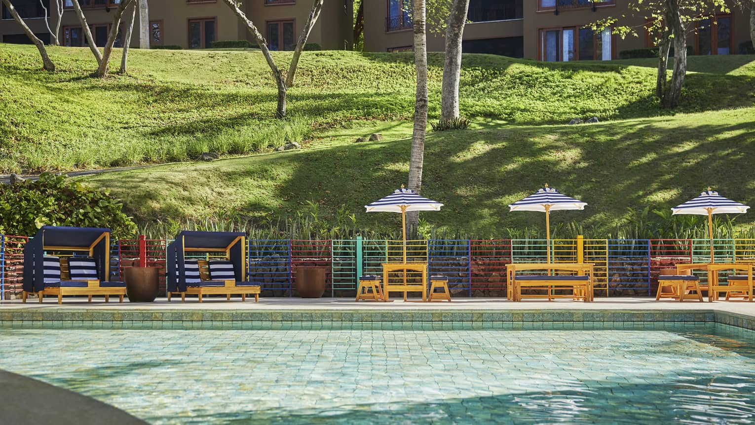 Several kids chairs line the barriers of a shallow children's pool.