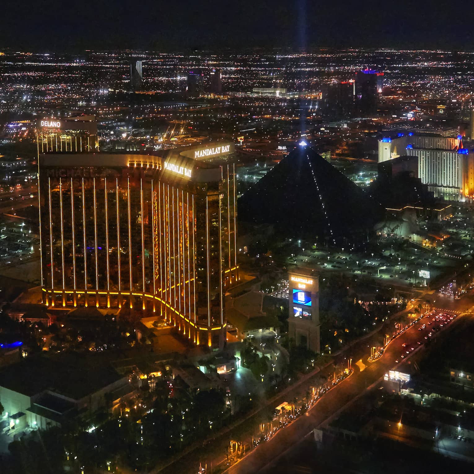 A bird's-eye view of the Las Vegas skyline at night, multicoloured lights illuminating casinos lining Las Vegas Boulevard.