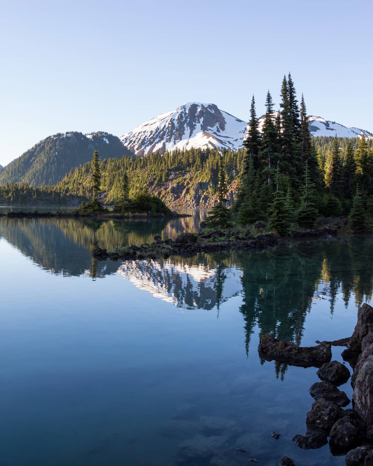 An alpine lake setting with a full mountain range in the background.