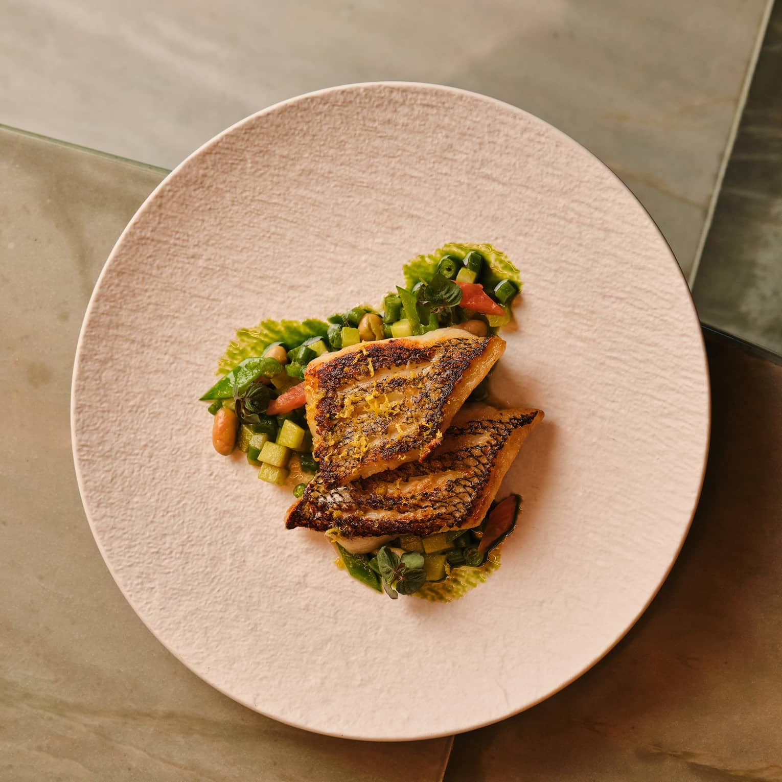 Sea bass with potatoes and greens on a plate