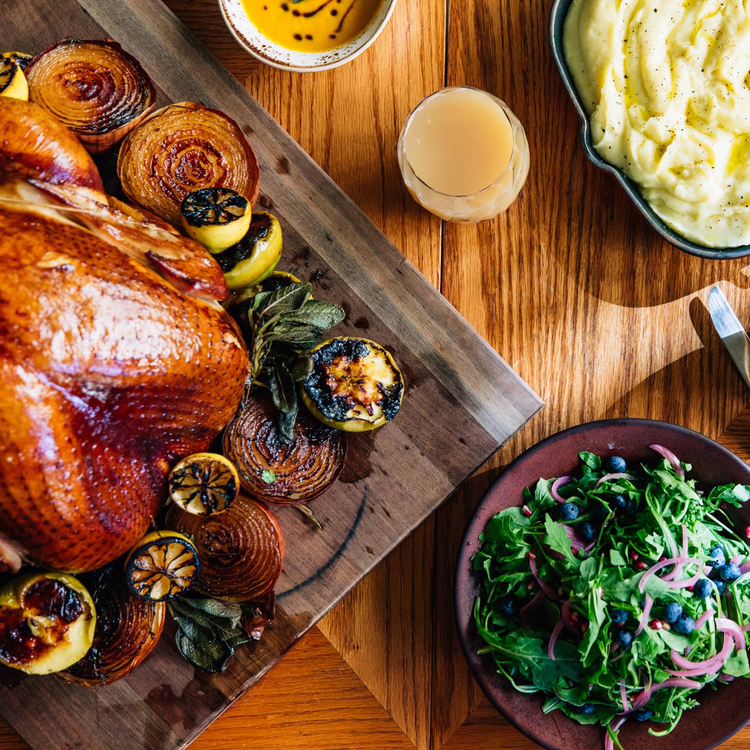 An aerial shot of a thanksgiving dinner including a roasted turkey with vegetables, mashed potatoes, salad and pumpkin pie