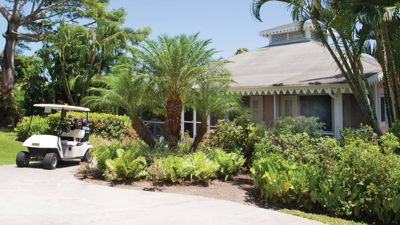 Golf cart parked on path by tropical plants, palm, Residence Villa