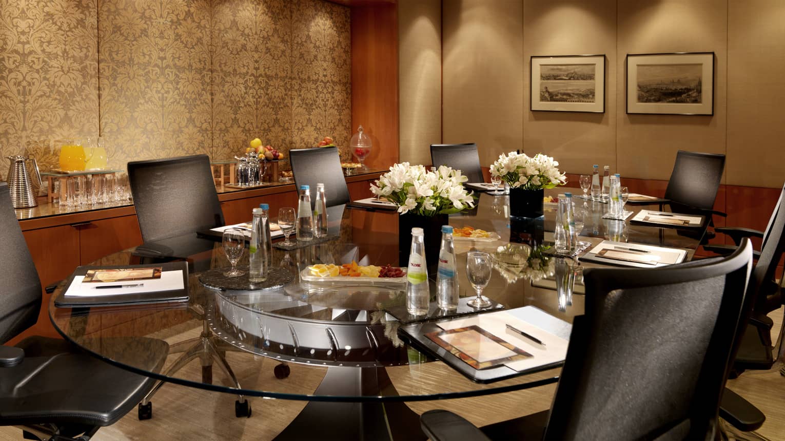 Spiga Meeting Room with round glass table lined with executive swivel chairs