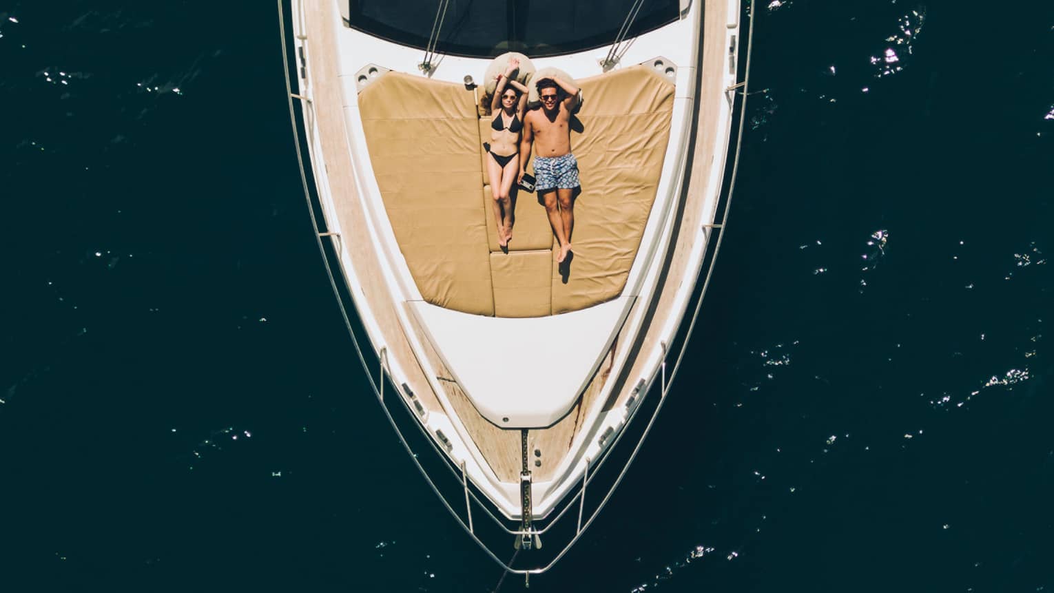 Aerial view of couple relaxing on the front of a large boat
