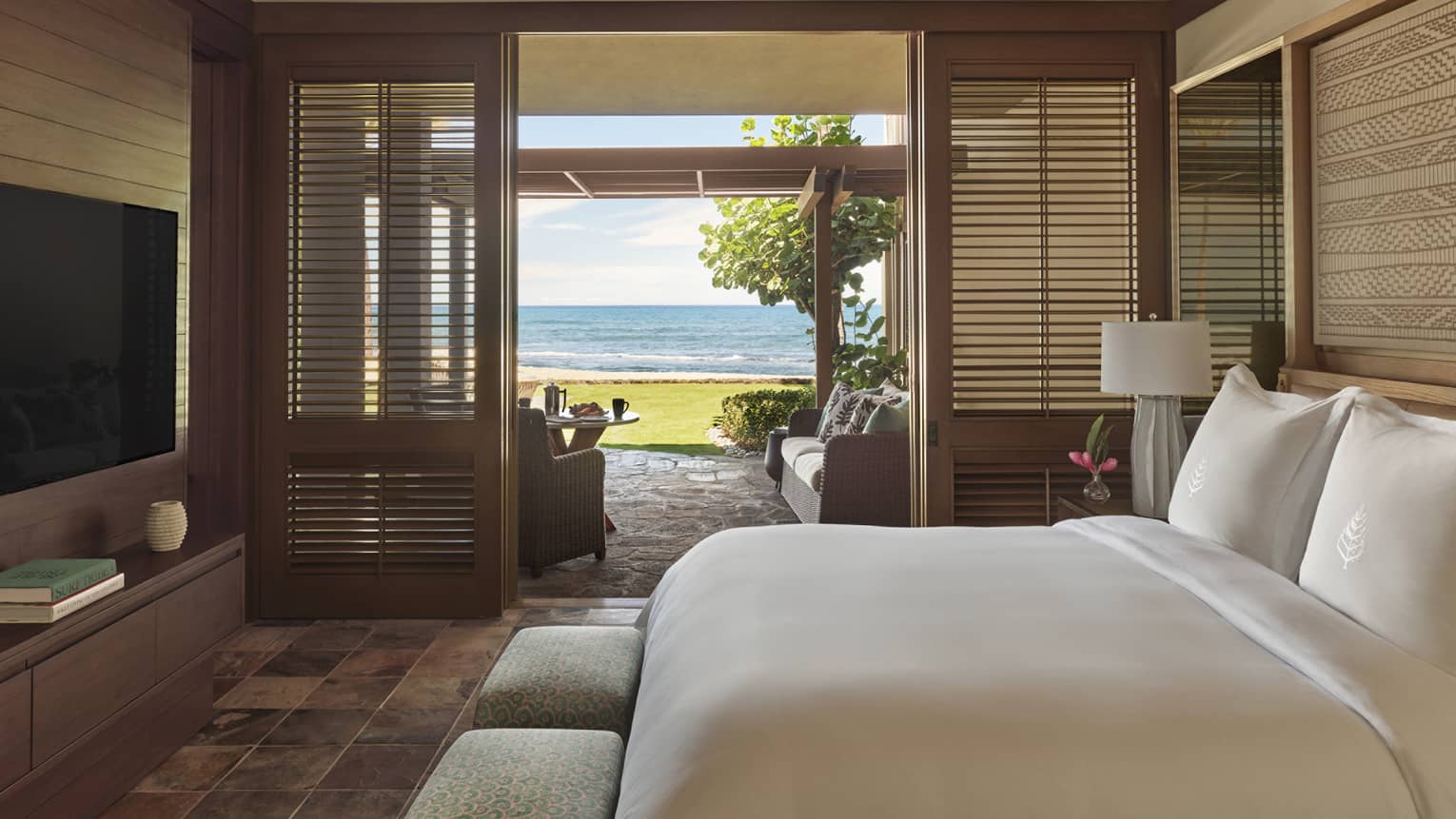 Bedroom with natural Hawaiian finishes, walk-out terrace with beach view