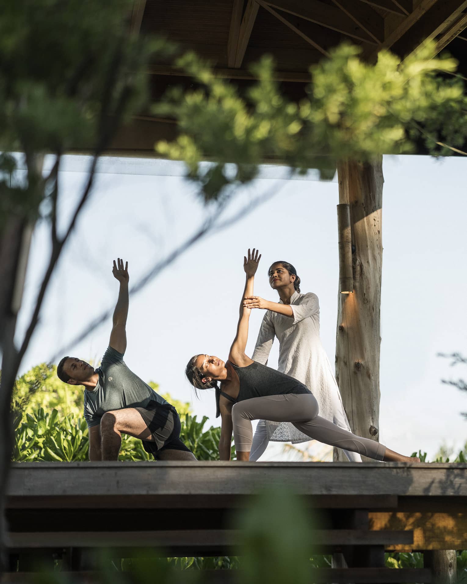 Couple stretching during outdoor yoga class