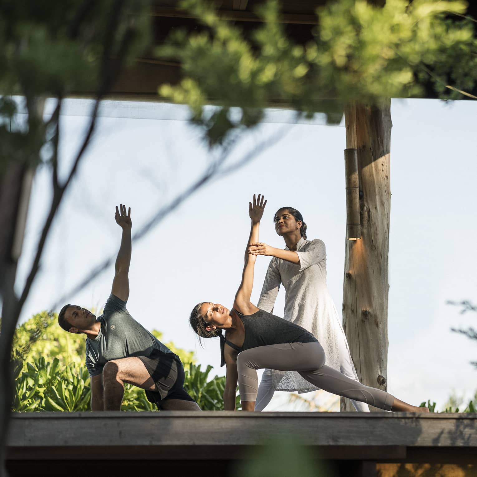 Couple stretching during outdoor yoga class
