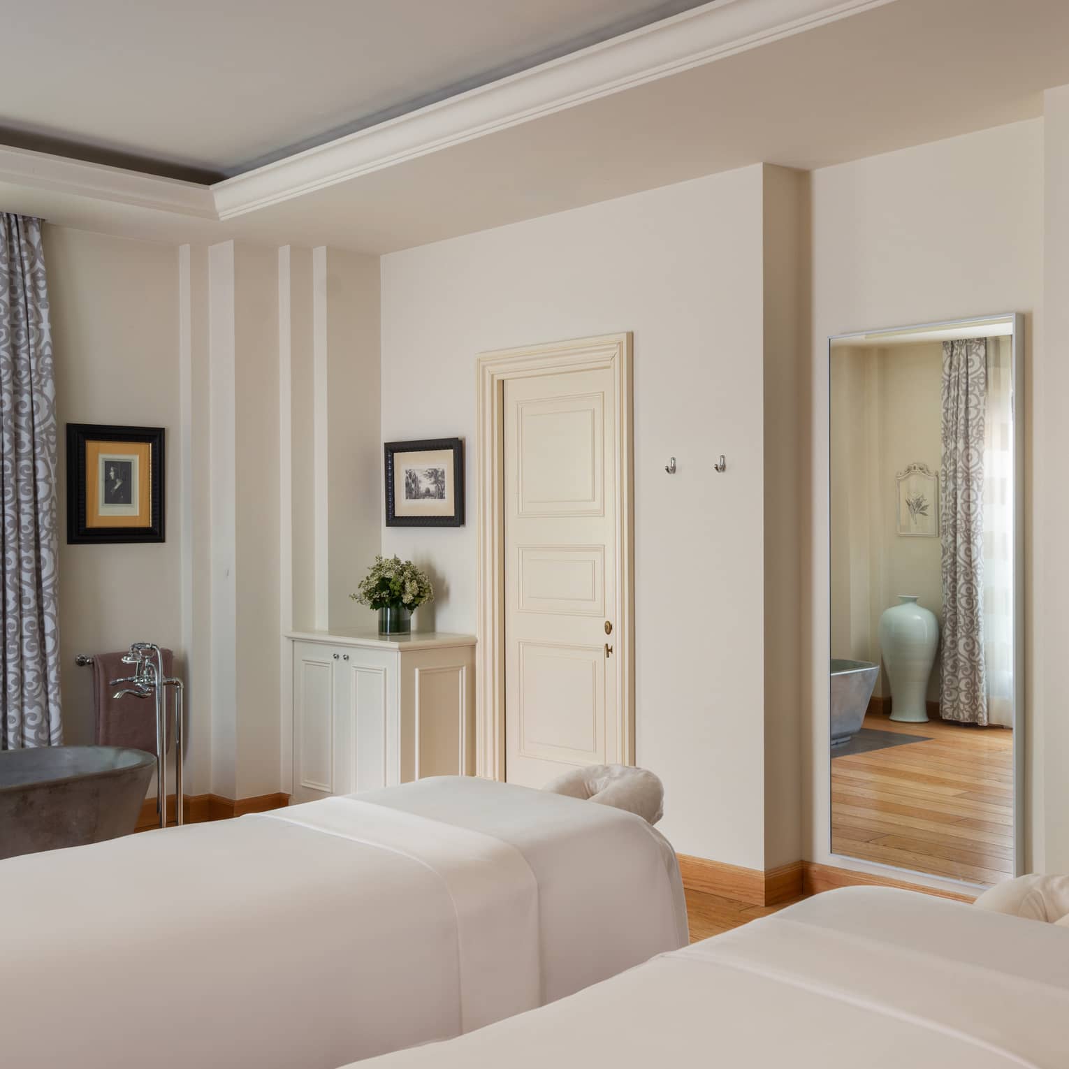 A light and spacious spa treatment room with two treatment tables side by side