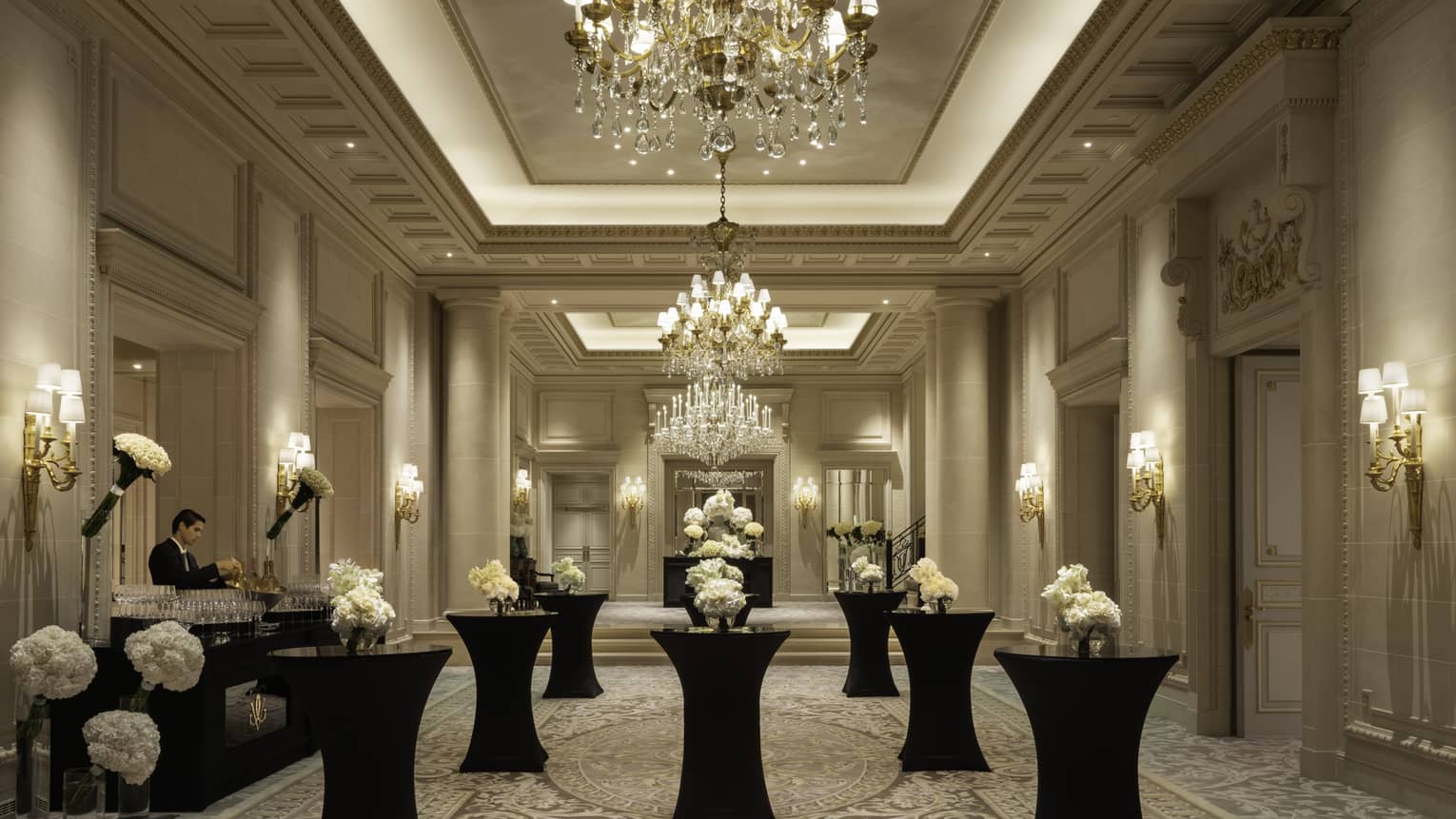 Monochromatic wedding venue with beautiful white flowers on black pillar tables