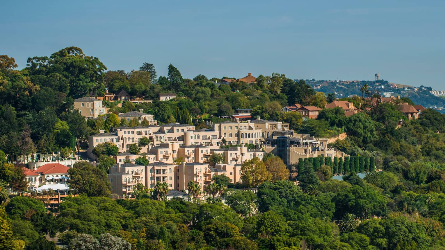 Aerial view of pink Four Seasons Hotel The Westcliff, Johannesburg building in green mountain