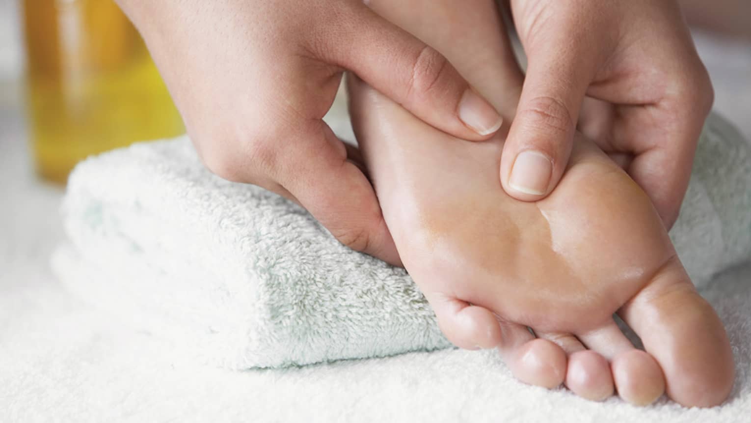 Close-up of hands massaging pressure points on feet