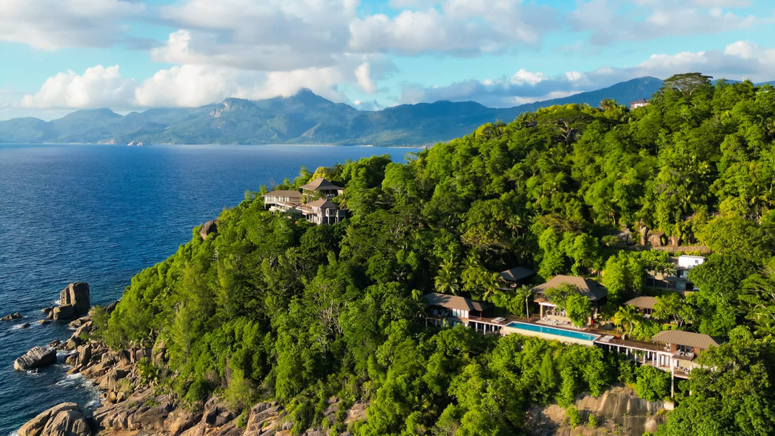 Aerial view of the property with lush foliage and ocean and mountain views