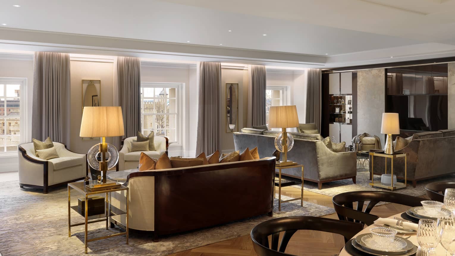 Large neutral living room with two seating vignettes flanked by lamps on side tables