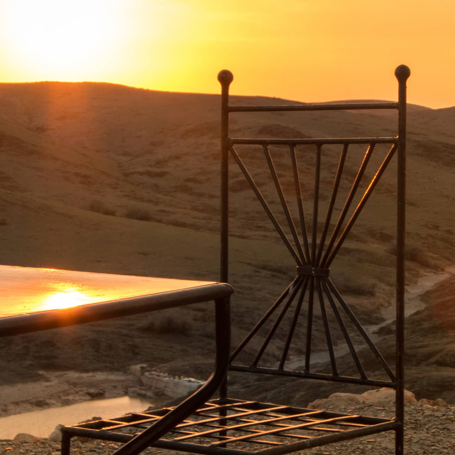 Corner of table, chair in desert at sunset