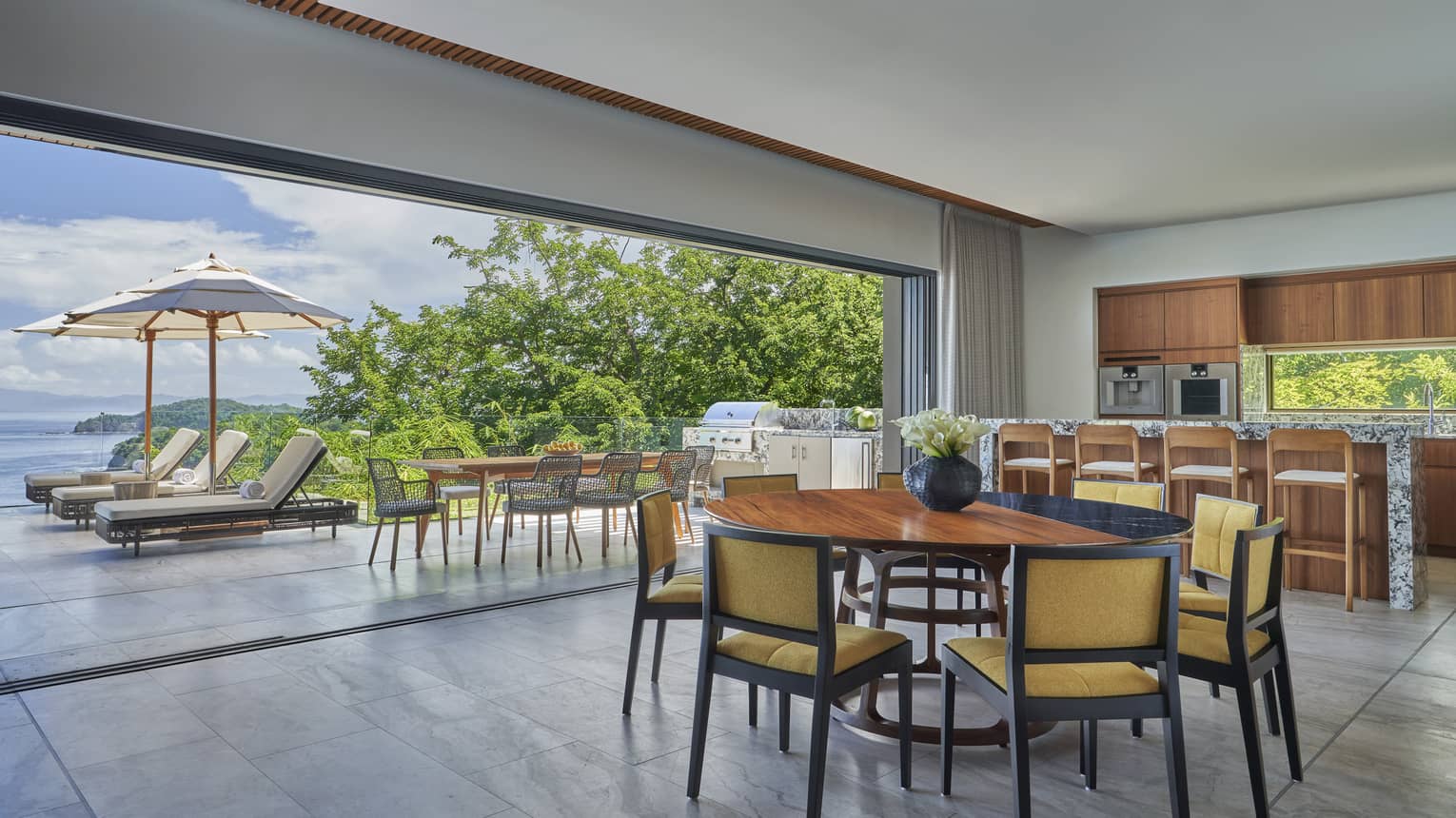 Kitchen and dining area opening to pool deck in private villa