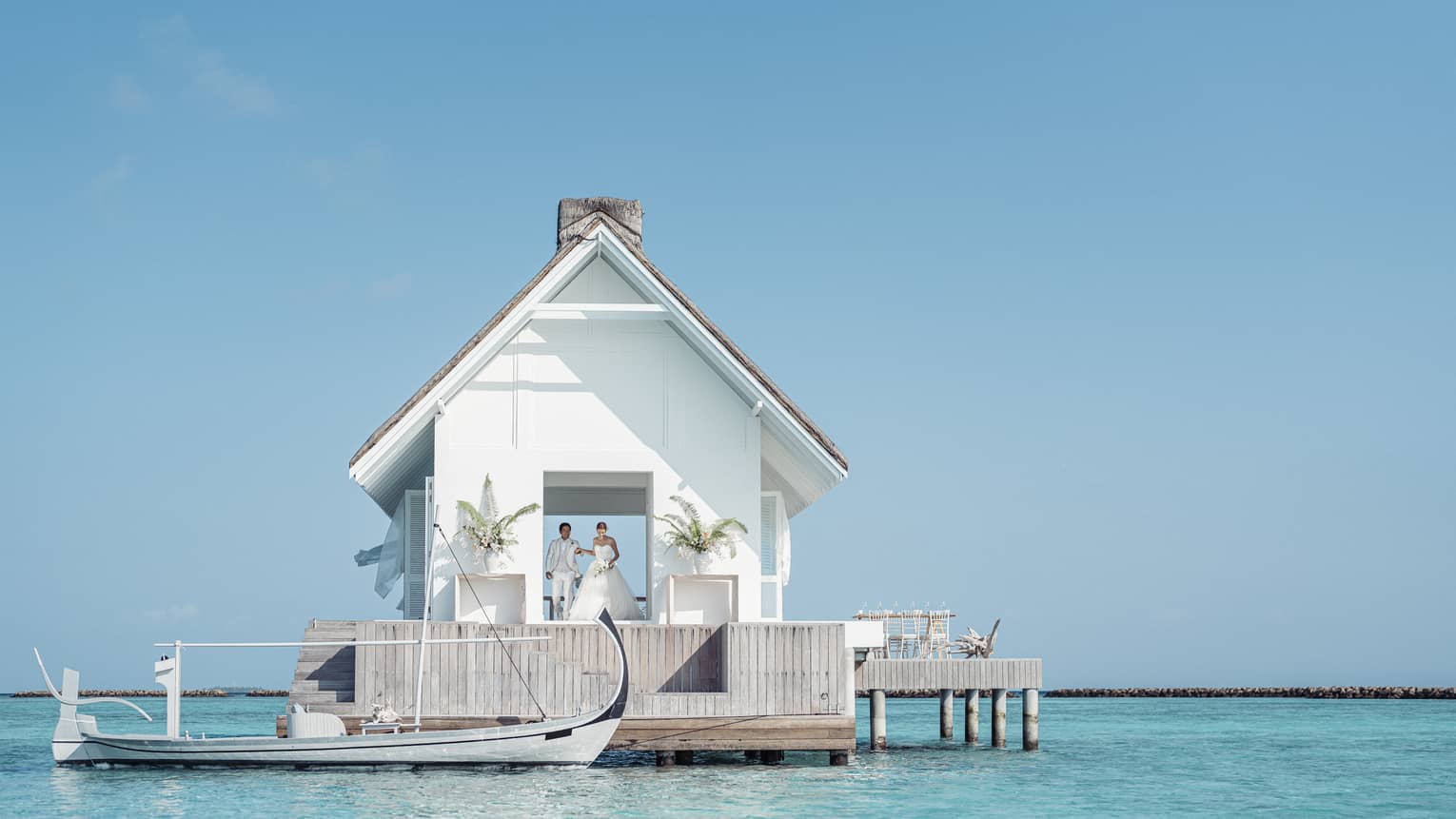 Bride and groom emerge from their overwater wedding pavilion