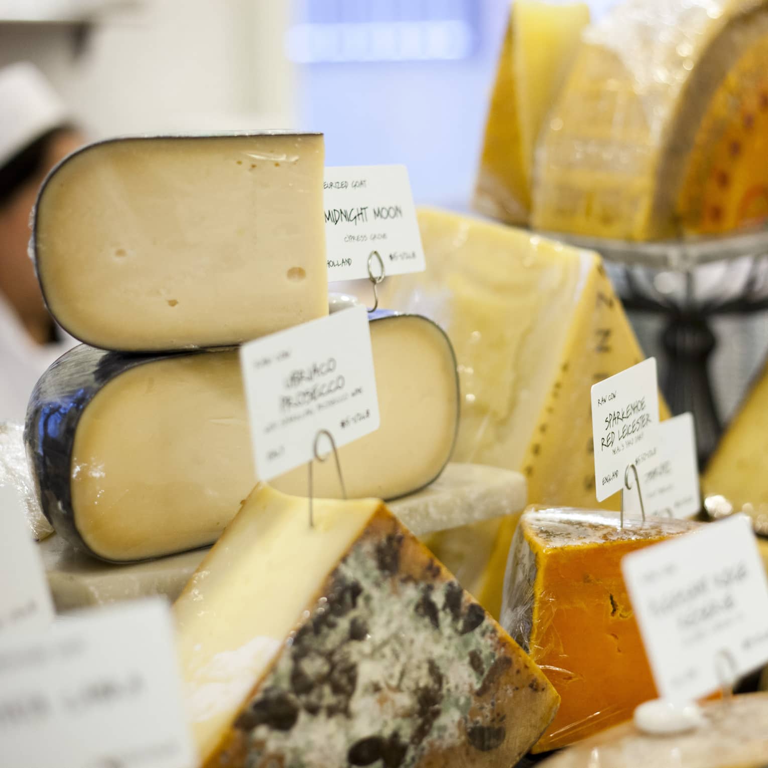 Close up of various cheeses with handwritten labels 