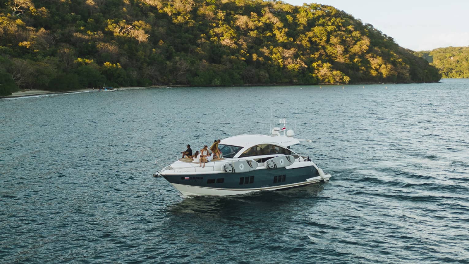 Power boat on water near green hills