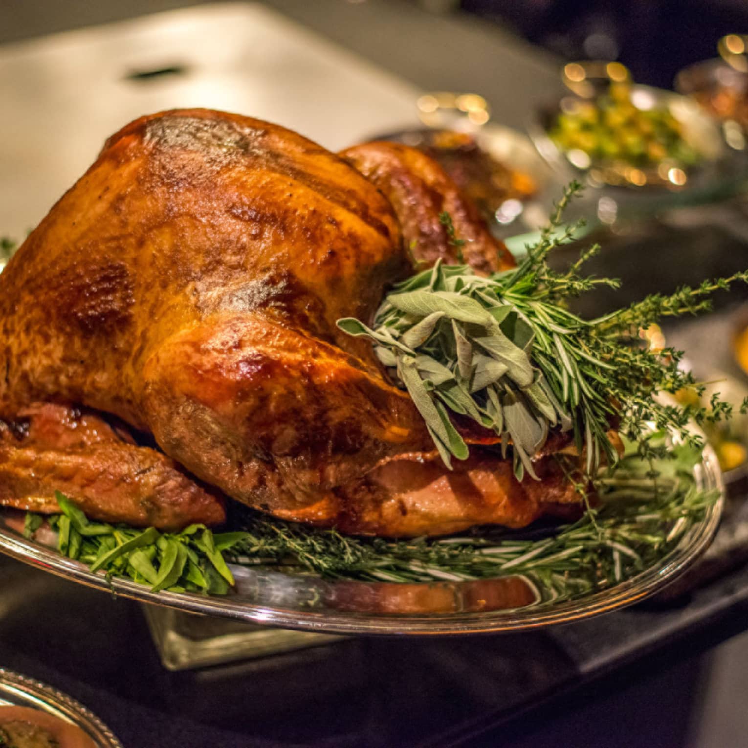 Roast turkey with fresh herbs on silver platter