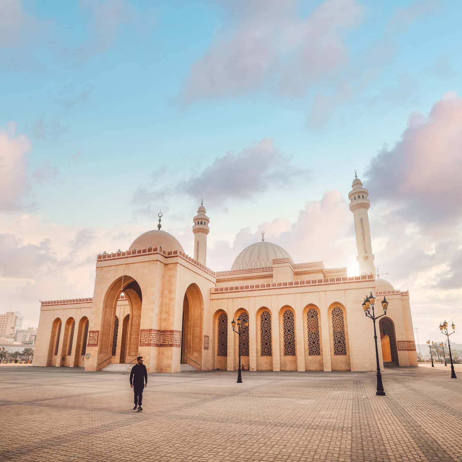 A large tan mosque with several pillars.