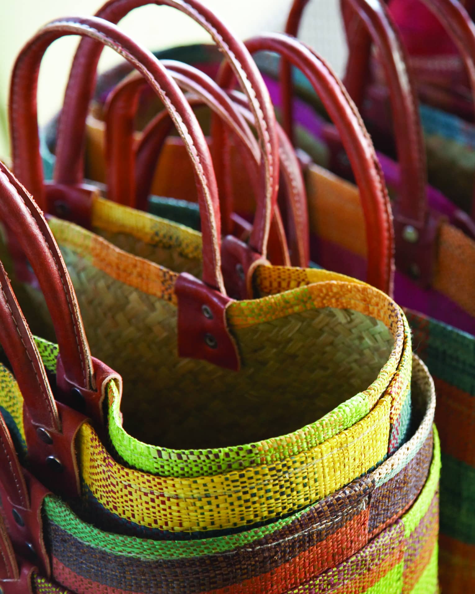 Multicolored woven shopping baskets with pink handles 