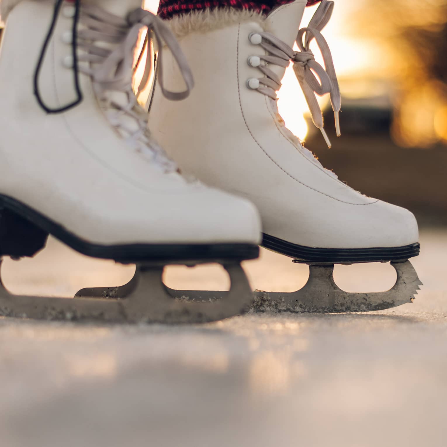 A pair of white ice skating boots.