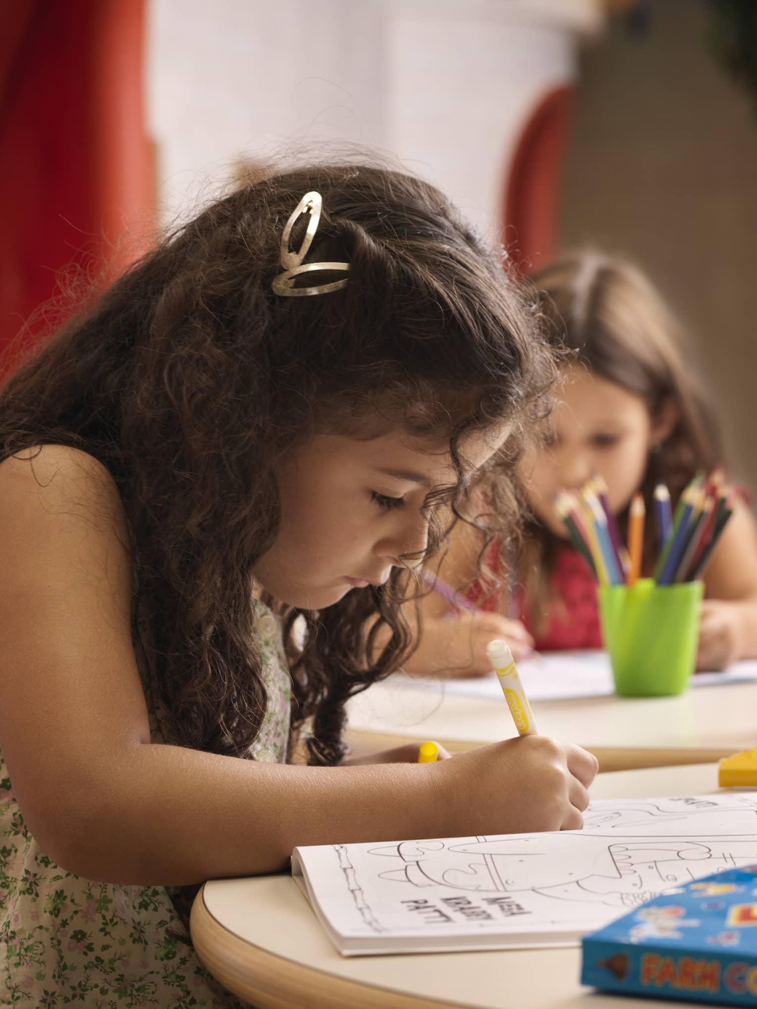 A group of young girls using markers on colouring books.