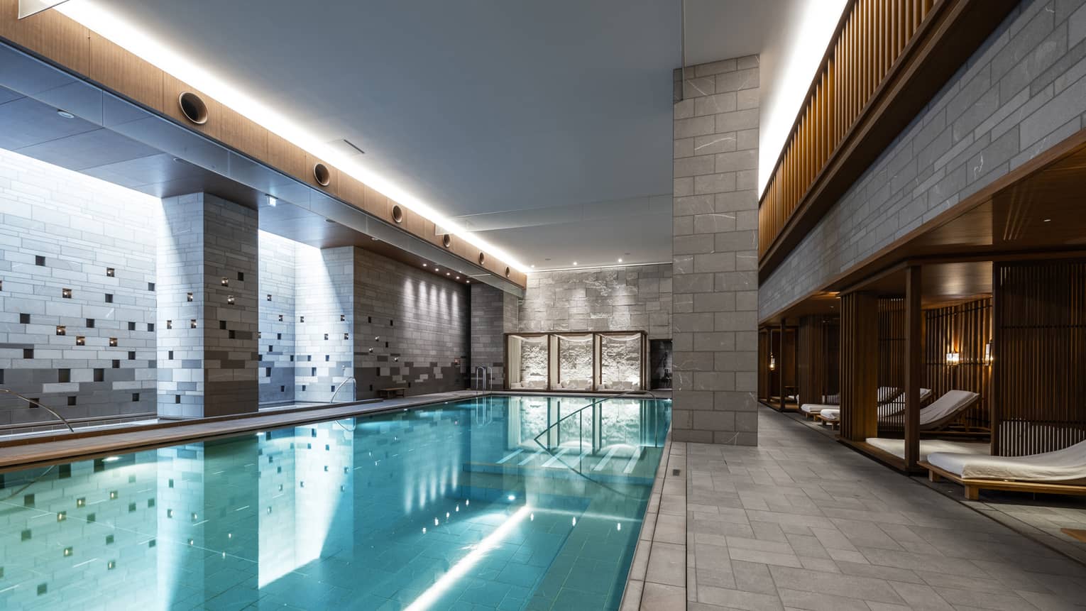 Indoor spa pool with chaise longues and grey columns