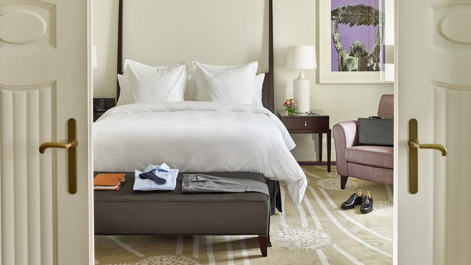 View in Chain Bridge Suite bedroom bed, bench through white French doors