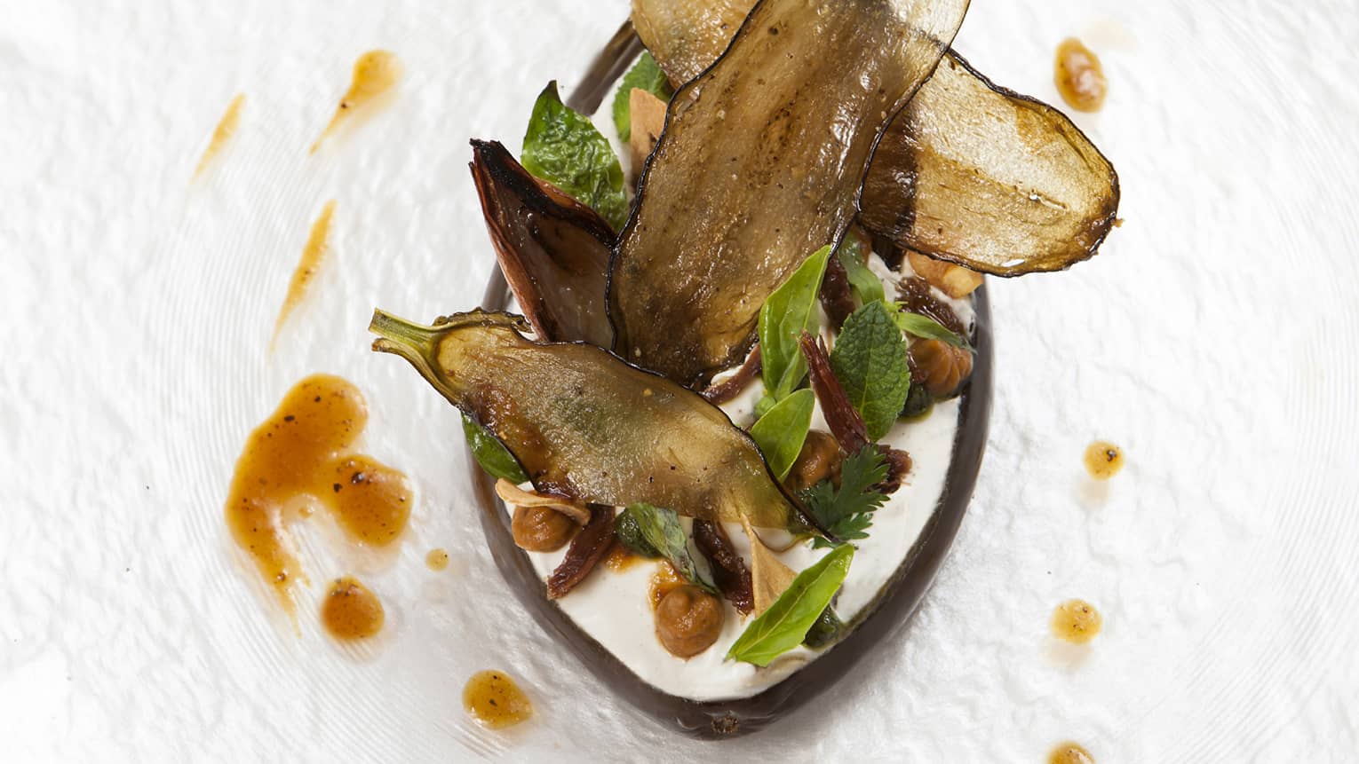 The Eggplant Signature Dish, served with basil and a creamy sauce