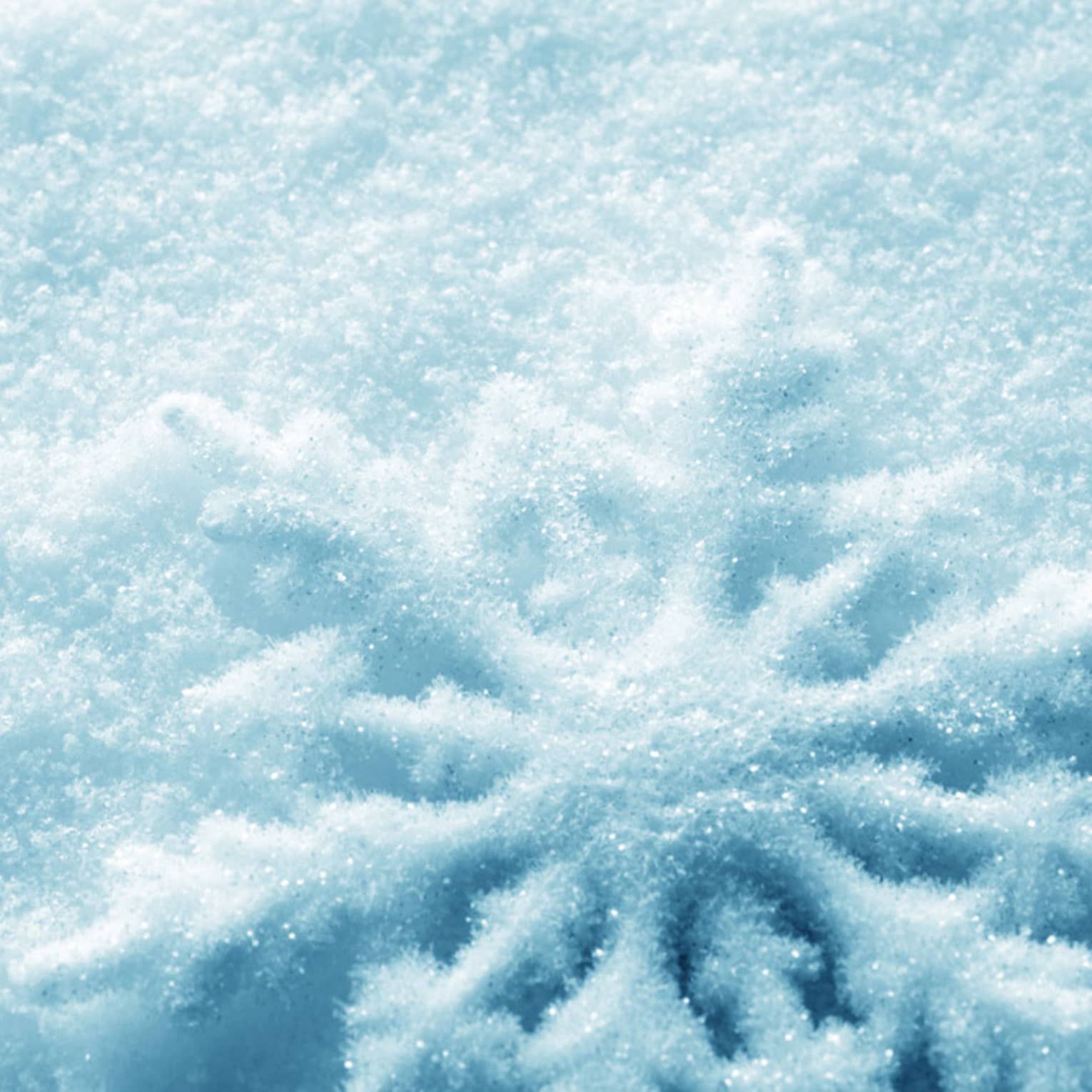 An intricate snowflake design is carved into the snow