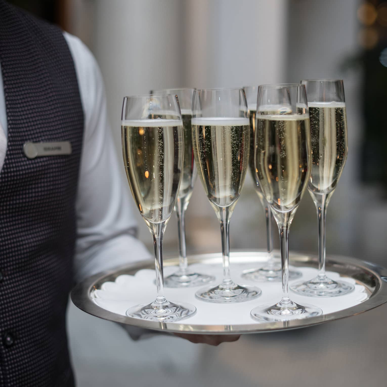 A team member carrying champagne on a tray.