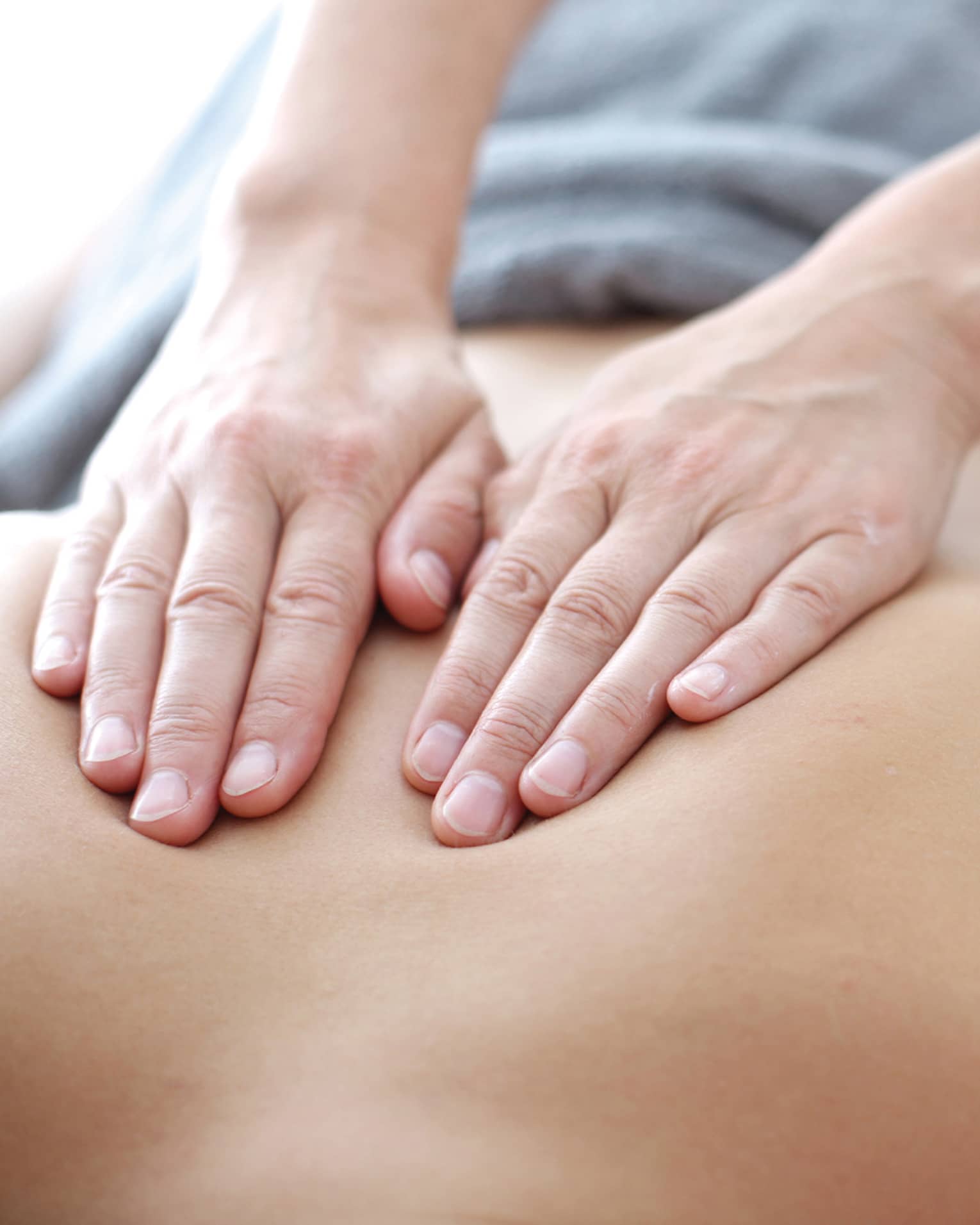 Hands massaging bare shoulders, back