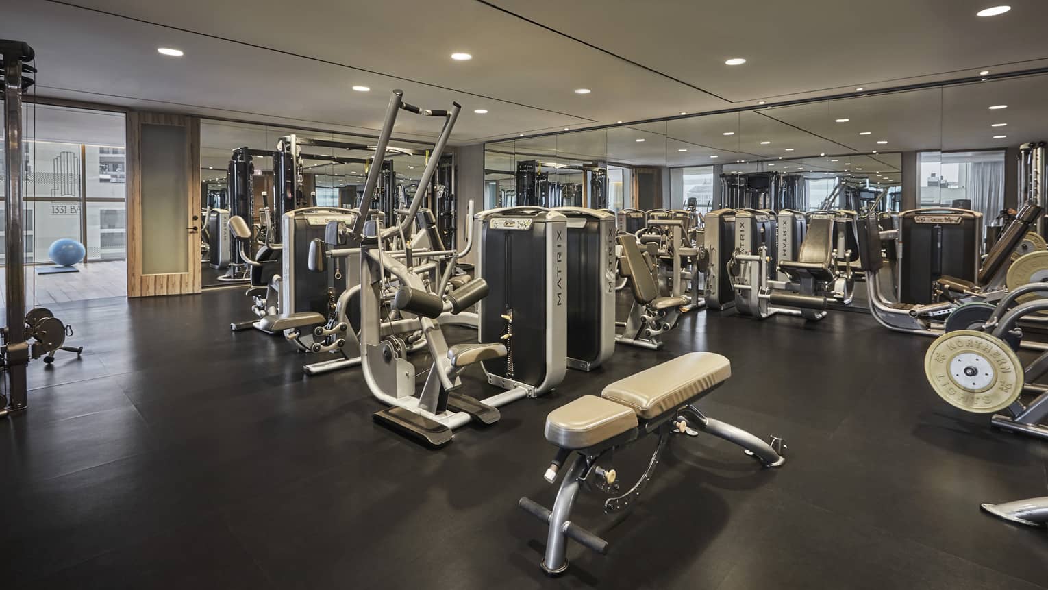 A fitness centre filled with weight machines, elipticals, treadmills, and other exercise machines. 