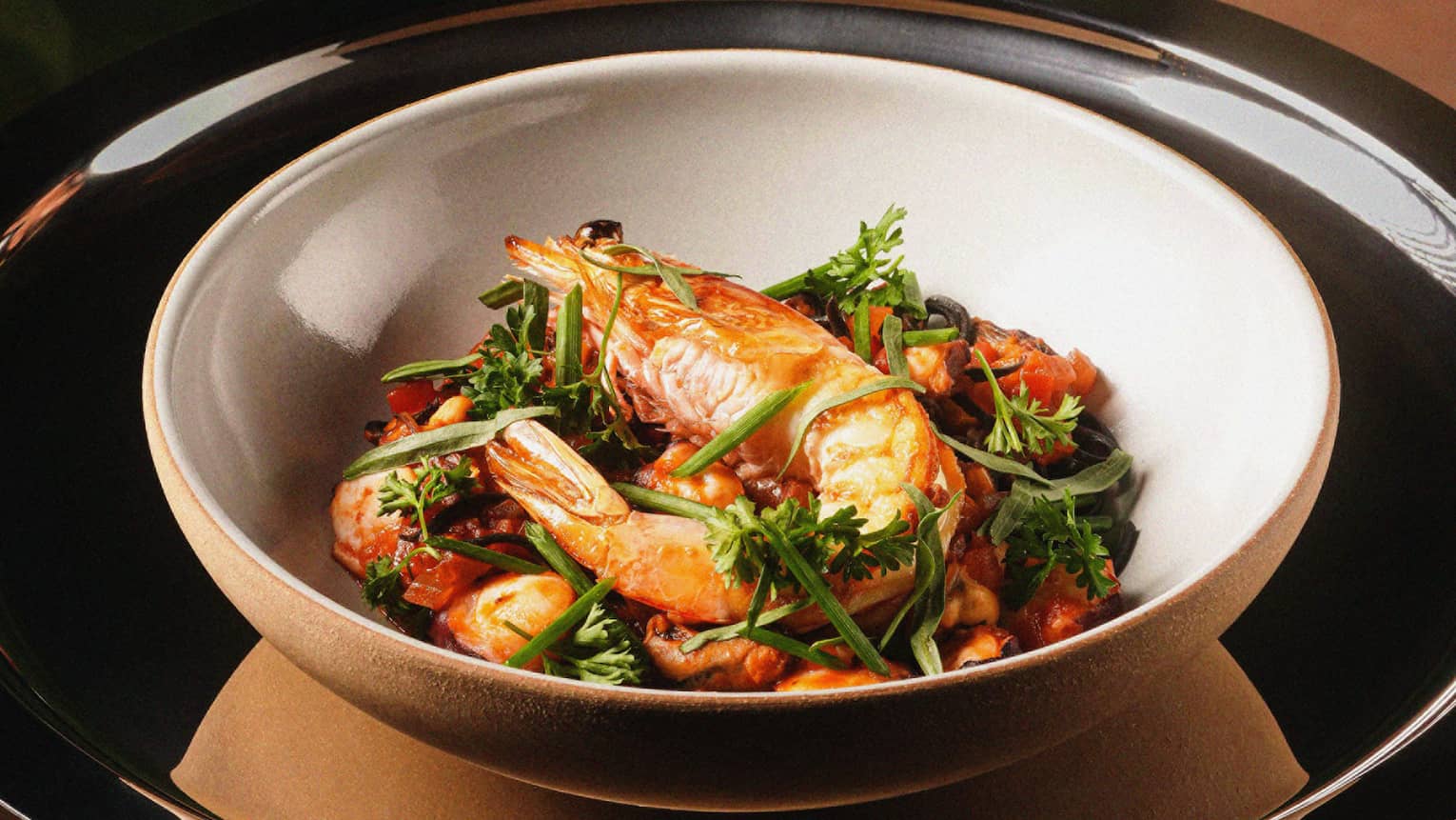 Pasta in a wide bowl with prawns and octopus