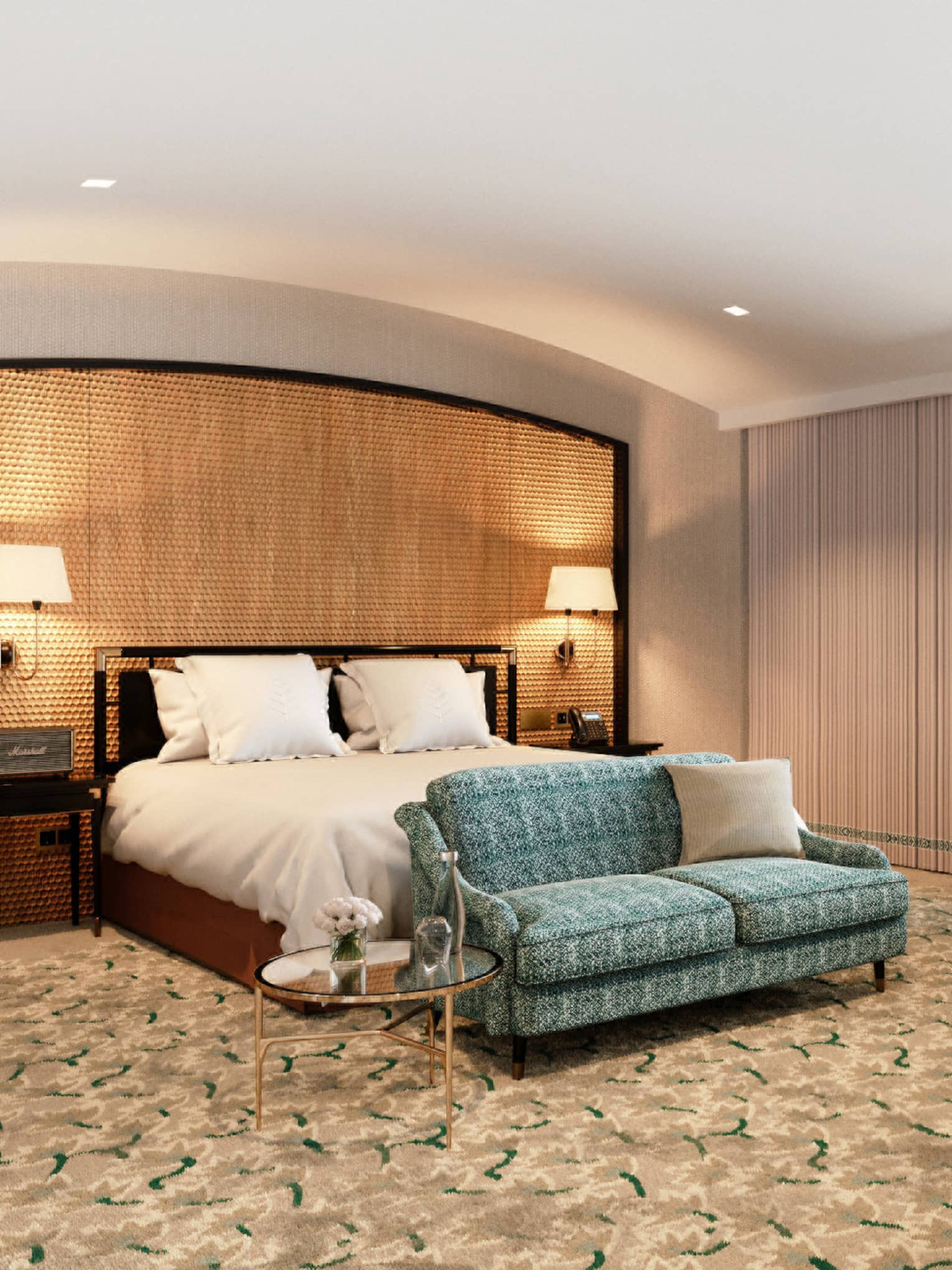 Spacious hotel room with a large bed, green patterned sofa, desk and large window with sheer curtains.