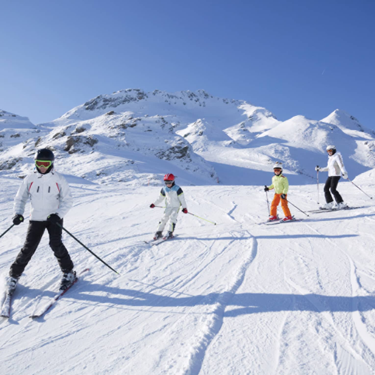 Family skis down snowy mountain