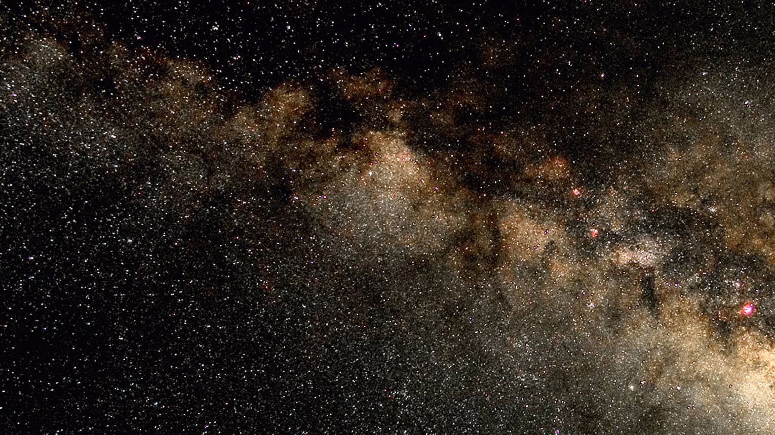 Silhouette of stargazer leaning into telescope against a starry sky, milky way