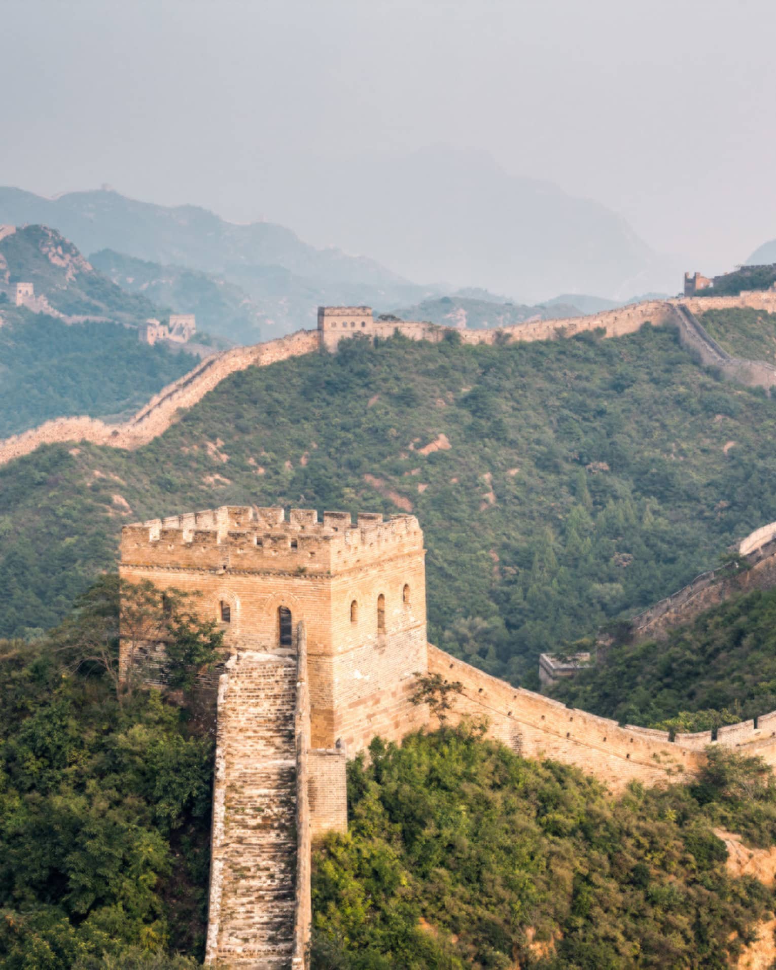 Great Wall of China winding along green mountain