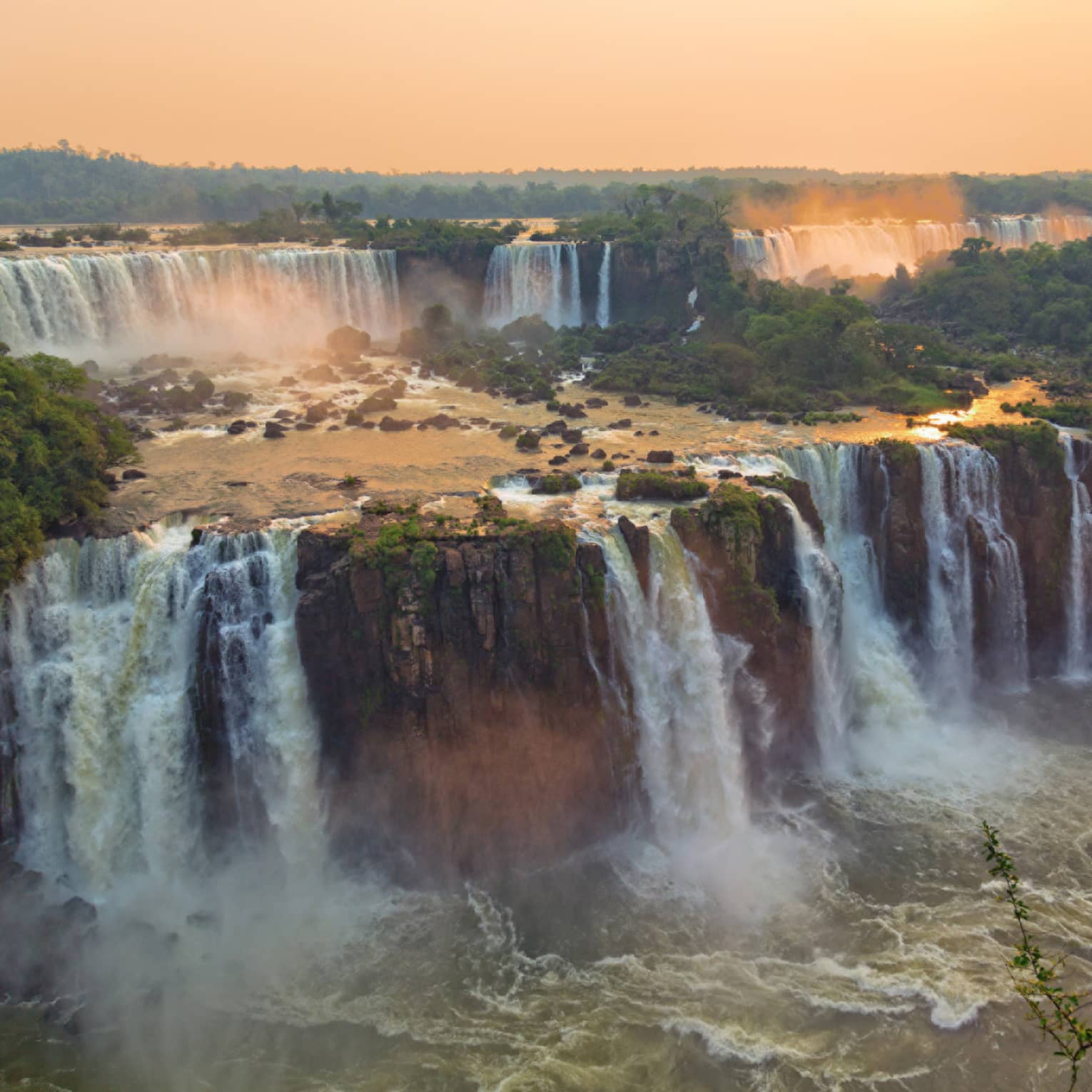 Sweeping view over Iguazu Falls large waterfalls at sunset