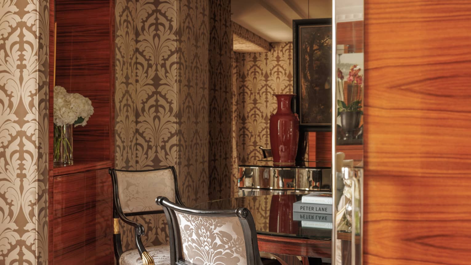 Dining room of Presidential Suite at Four Seasons Hotel London, featuring a round table with four chairs, wall paper and chandelier