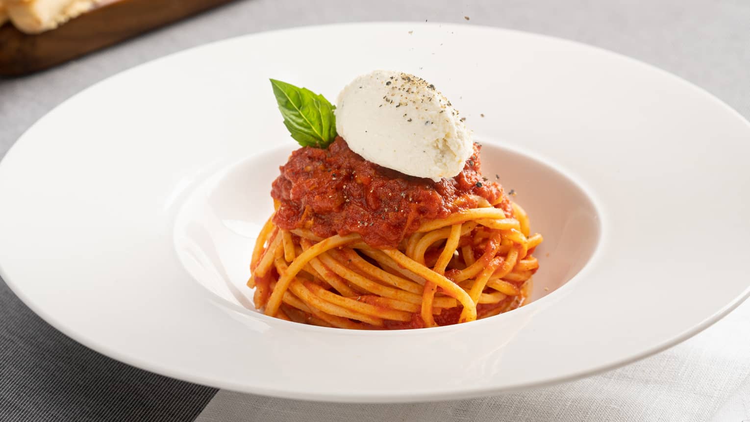 Spaghetti Pomodoro Burrata in a white, large-rimmed bowl