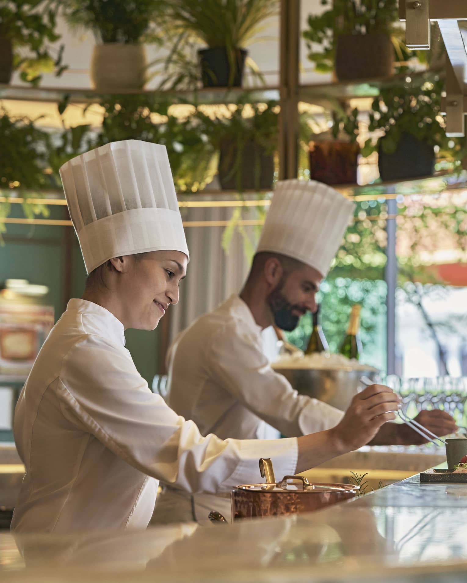 Male and female chef in action at bar counter of restaruant