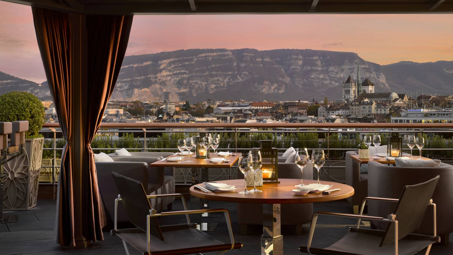 Close-up of patio dining table with wine glasses, sunset view of mountains