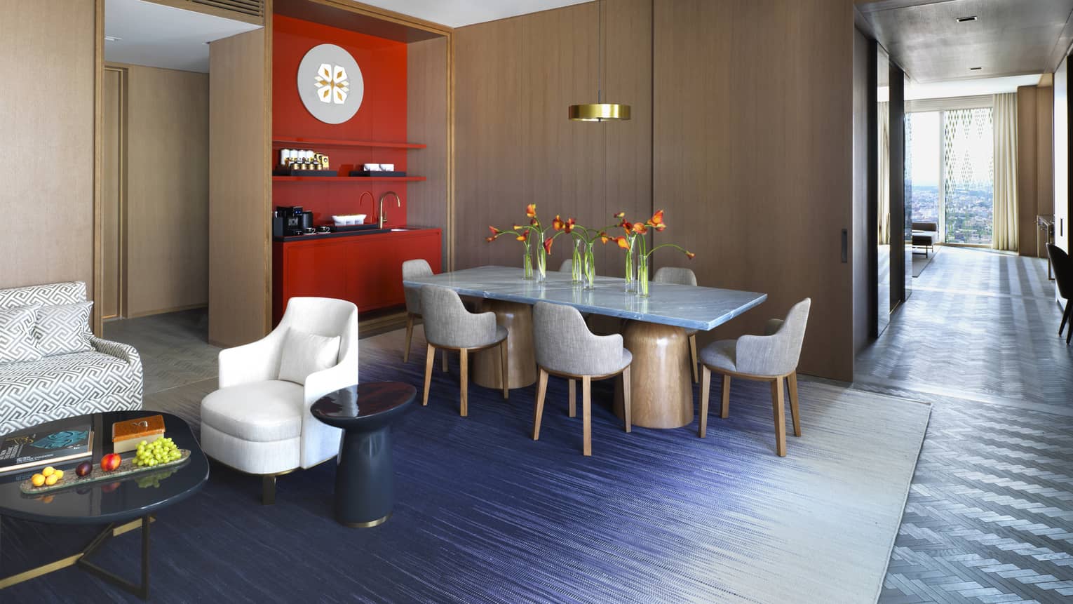 Ambassador Suite private dining table in front of wood panel bar, red wet bar, modern sofa, chair