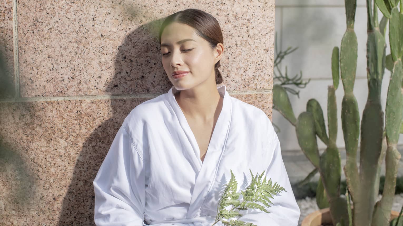 A woman in a spa robe enjoying the afterglow of a massage at the Four Seasons Hong Kong Spa.