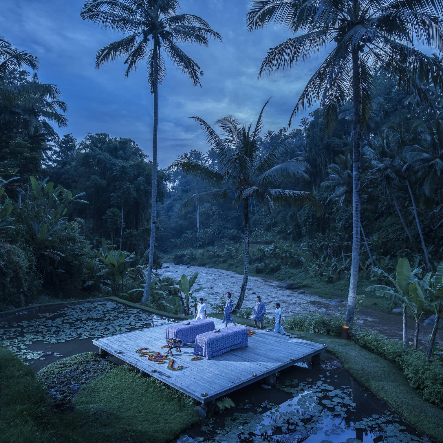 A few wellness experts preparing for a private outdoor treatment at dawn