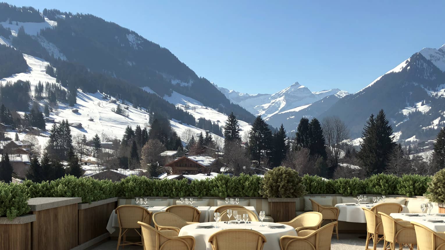 Outdoor dining setup with snow-capped mountains in the background