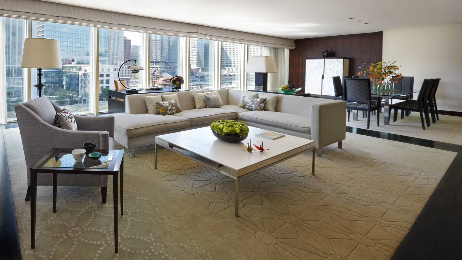 Chairman's Suite modern L-shaped grey sofa, armchair coffee table, wall of windows