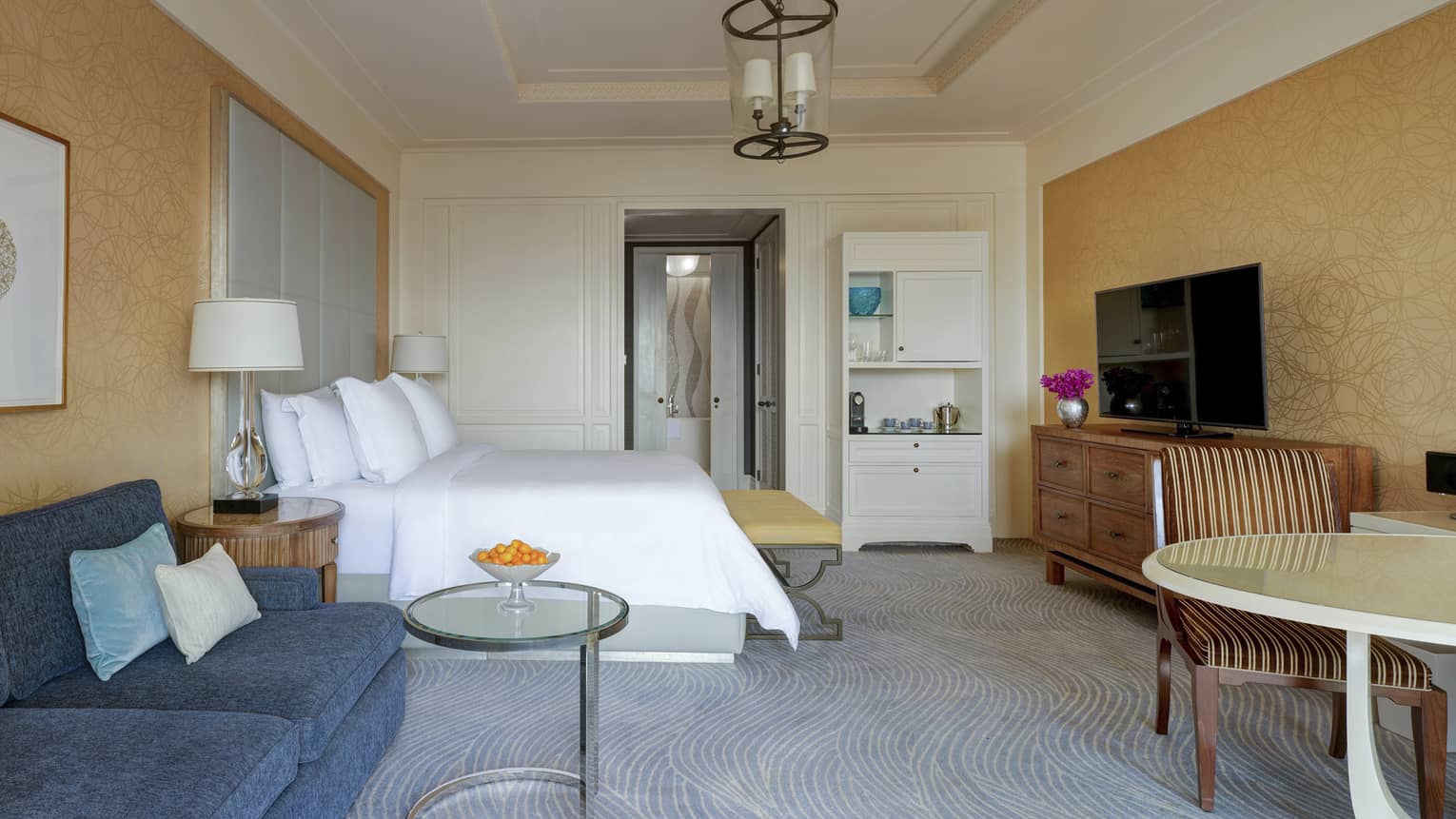 Bedroom with bed, table and chairs, dark blue sofa